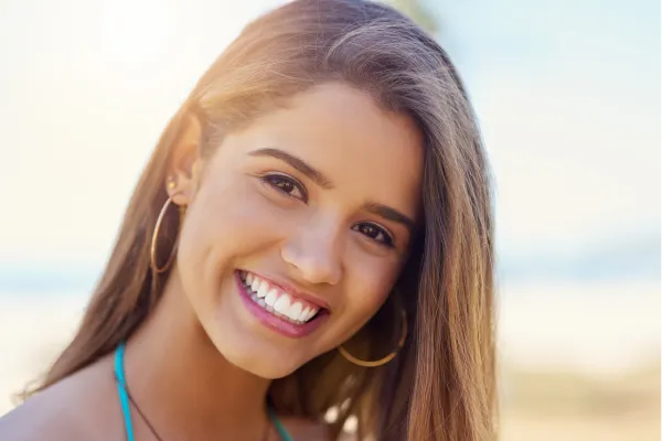 Smiling woman showing bright white teeth, representing results from teeth whitening in Stuart for a more confident smile